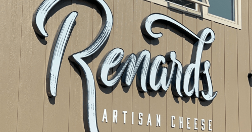 White sign on a tan colored wall that reads Renards Artisan Cheesee
