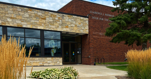 A red and cream brick building with Rodman Center for the Performing Arts on the front of it.