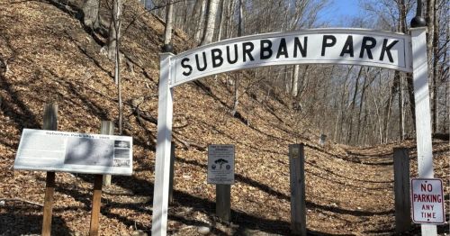 An old arch that says "Suburban Park" marking a trailhead.