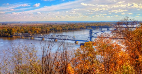 The Wabash Bridge spans the Mississippi River at Hannibal, Missouri. Vibrant fall foliage lines the river's banks.