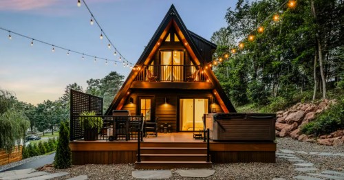 Private outdoor hot tub and deck under string lights on a modern A-frame cabin in Damascus, PA.