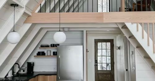 The white interior of an A-frame cabin’s kitchen.