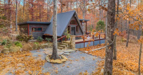 A-frame cabin in Alabama surrounded by fall foliage with bright orange, red, and yellow leaves