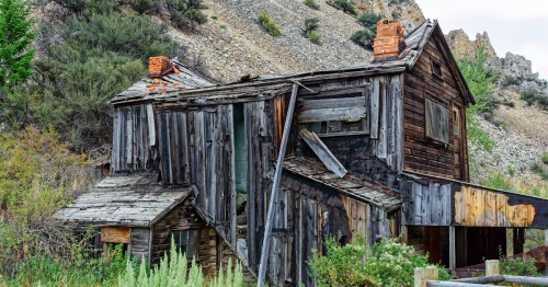 An abandoned building against a mountain within a ghost town in Idaho.