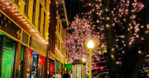 A main street decorated with holiday lights.