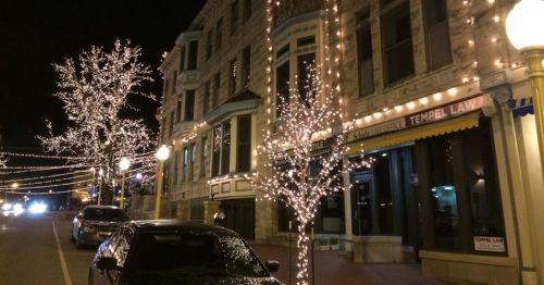 A main street decorated with holiday lights.
