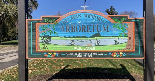 A wooden sign marking the entrance of the Delavan Memorial Arboretum