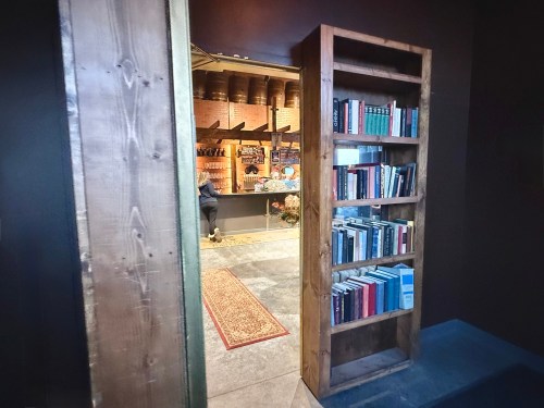 A bookshelf revealing a hidden door opening into Speakeasy 41 in Nebraska.
