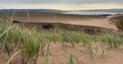 A sandy dune hike overlooking a lake.