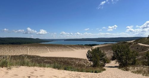 A sandy dune hike overlooking a lake.