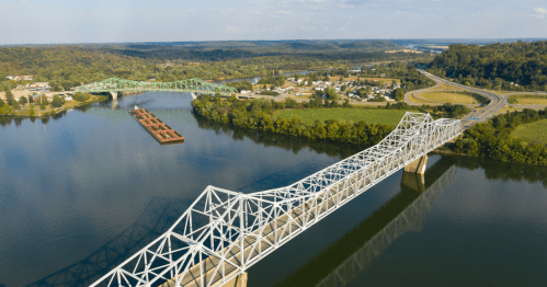 An aerial view of a barge on the Ohio River, bridges, and Gallipolis, Ohio