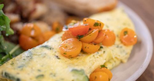 An omelette with tomatoes on it.
