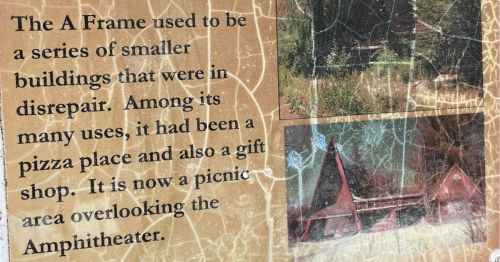 A plaque describing an old A frame building.