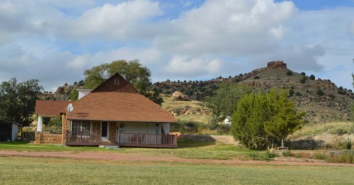 exterior of the mesa valley guesthouse surrounded by green acreage and hills in oklahoma's panhandle