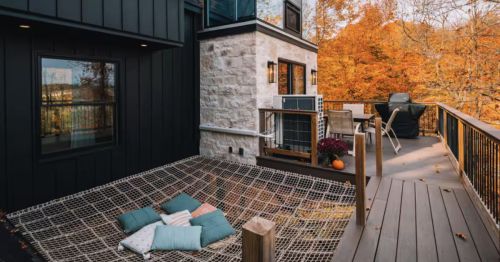 An outdoor patio with a netted lounge area with pillows and an outdoor patio.