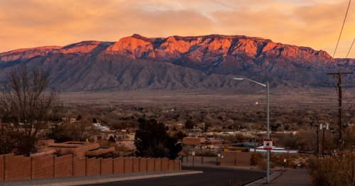 A fiery sunset over the Sandia Mountains and the town of Rio Rancho, New Mexico.