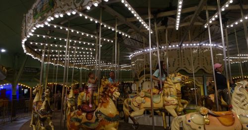 Children rinding a carousel at night.