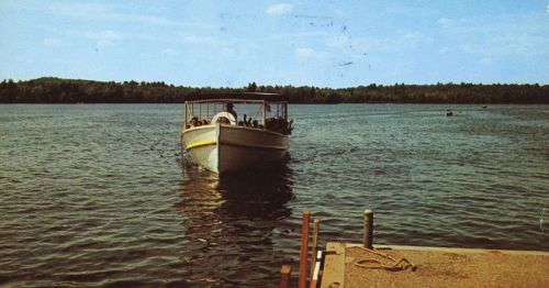 A boat approaching a dock on a lake.