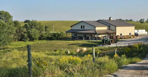 A farmhouse overlooking a pasture.
