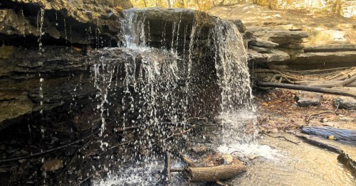 A waterfall sparkles in the sunlight.