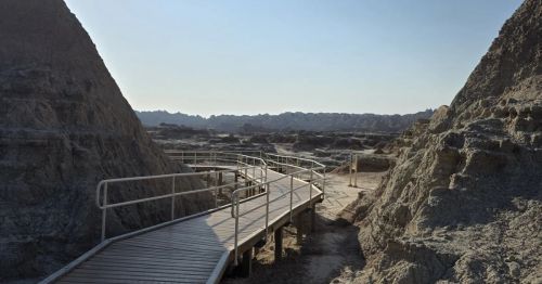 A boardwalk trail going through large rock formations.