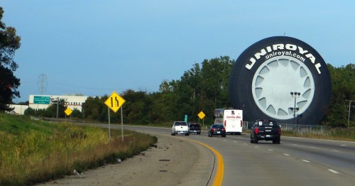 A giant Uniroyal stands in Allen Park, Michigan, alongside a freeway with cars driving by.