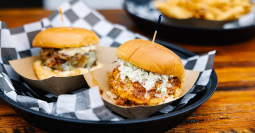Two burgers on a checkered plate.