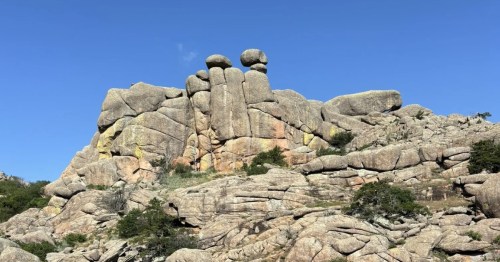 in the distance we see the rock formation knwn as "crab eyes," which iis a large boulder with two small round rocks on top to look like crab eyes in oklahoma's wilderness