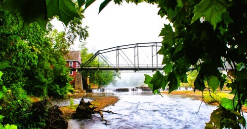 War Eagle Mill in Rogers, Arkansas, with a flowing creek and a bridge.