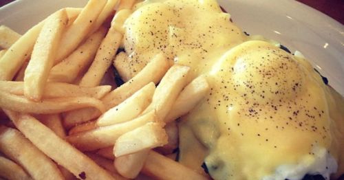 A closeup of french fries and eggs.