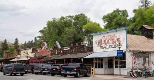 A row of Old West looking buildings and a row of vehicles in front of them in Winthrop