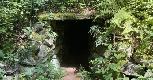 the entrance to nashobe brook stone chamber, a historic chamber being taken over by nature in massachusetts