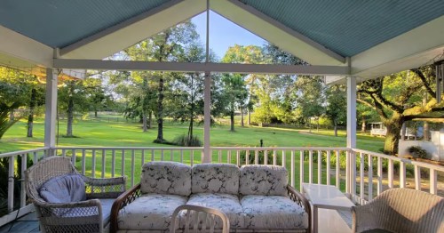view of farmland and a fenced-in area for horses in the distance as seen from a porch of a farm stay airbnb in Louisiana