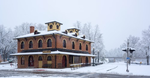 The historic red brick train depot in Galena, Illinois, sits near the tracks under a blanket of fresh snow.