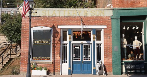 Small brick building with a blue front door.
