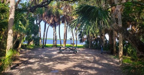 A scenic waterfront campsite with lush tropical vegetation at Fort De Soto Park in Florida.