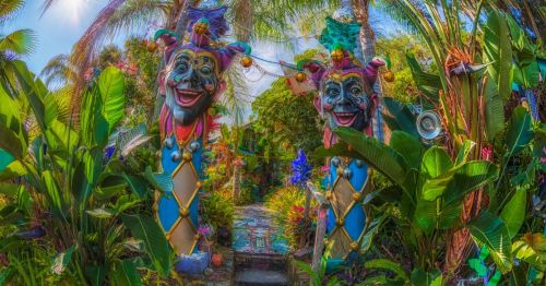 Entrance of Whimzeyland, a hidden gem in Florida, with two colorful, psychedelic jesters in front of the pathway.