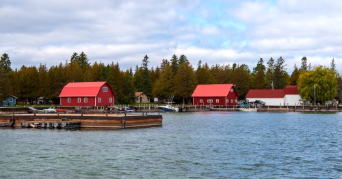 Red boathouses line the shore at Jackson Harbor on Washington Island, Door County, Wisconsin.