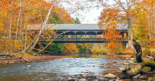 Mohican Covered Bridge spanning over clear fork Mohican river in autumn. Mohican State Park.