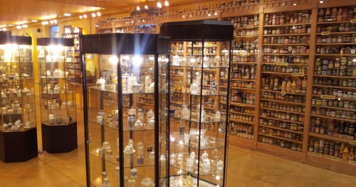 Wooden shelves with tiny mustard jars and bottles inside the National Mustard Museum.