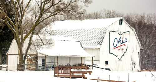 Winter snow scene with an old historic Ohio barn covered with snow.