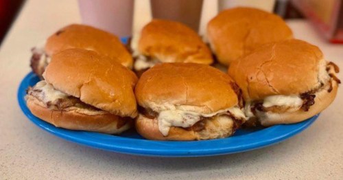 a blue plate holding 6 burgers topped with cheese