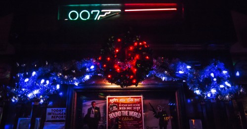 Blue and red holiday lights below a red, white, and blue 007 neon sign.
