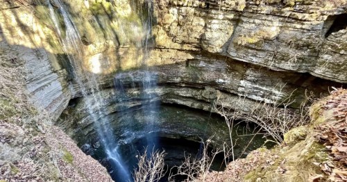 A sinkhole in Alabama with water falling into it.