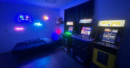 interior of a game room wit gaming consoles and neon signs at an airbnb in oklahoma