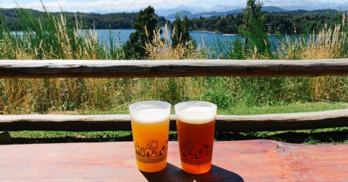 two beers in a wood table at a beer garden with incredible views of the lake