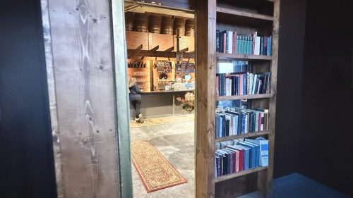 A bookshelf revealing a hidden door opening into Speakeasy 41 in Nebraska.