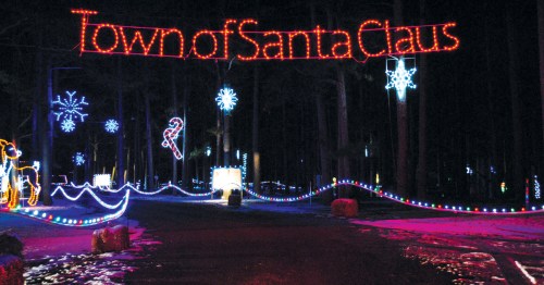 "Town of Santa Claus" appears in lights over a night scene.