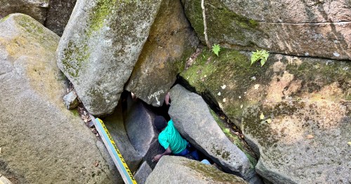 A view from above the Lost River Gorge & Boulder Caves in North Woodstock, New Hampshire as a boy enters a cave.