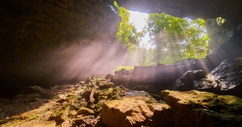 Light pours into a cave through an opening.
